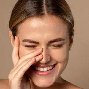 Woman gently applying skincare cream to smooth fine lines & early aging signs