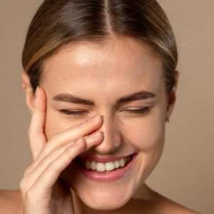 Woman gently applying skincare cream to smooth fine lines and early aging signs