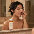 Woman removing eye makeup with Norvia Co. Essentials Makeup Remover