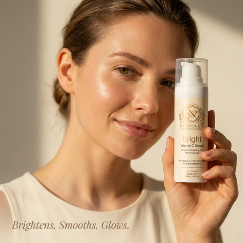 Woman with glowing skin holding Norvia Co. Bright Vitamin C Serum