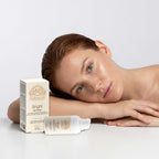 Brightening Eye Cream in a white pump bottle with cream-colored box packaging and gold botanical branding beside a woman