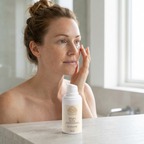 Brightening Eye Cream in a white pump bottle with gold label, shown as a woman gently applies cream beneath her eye