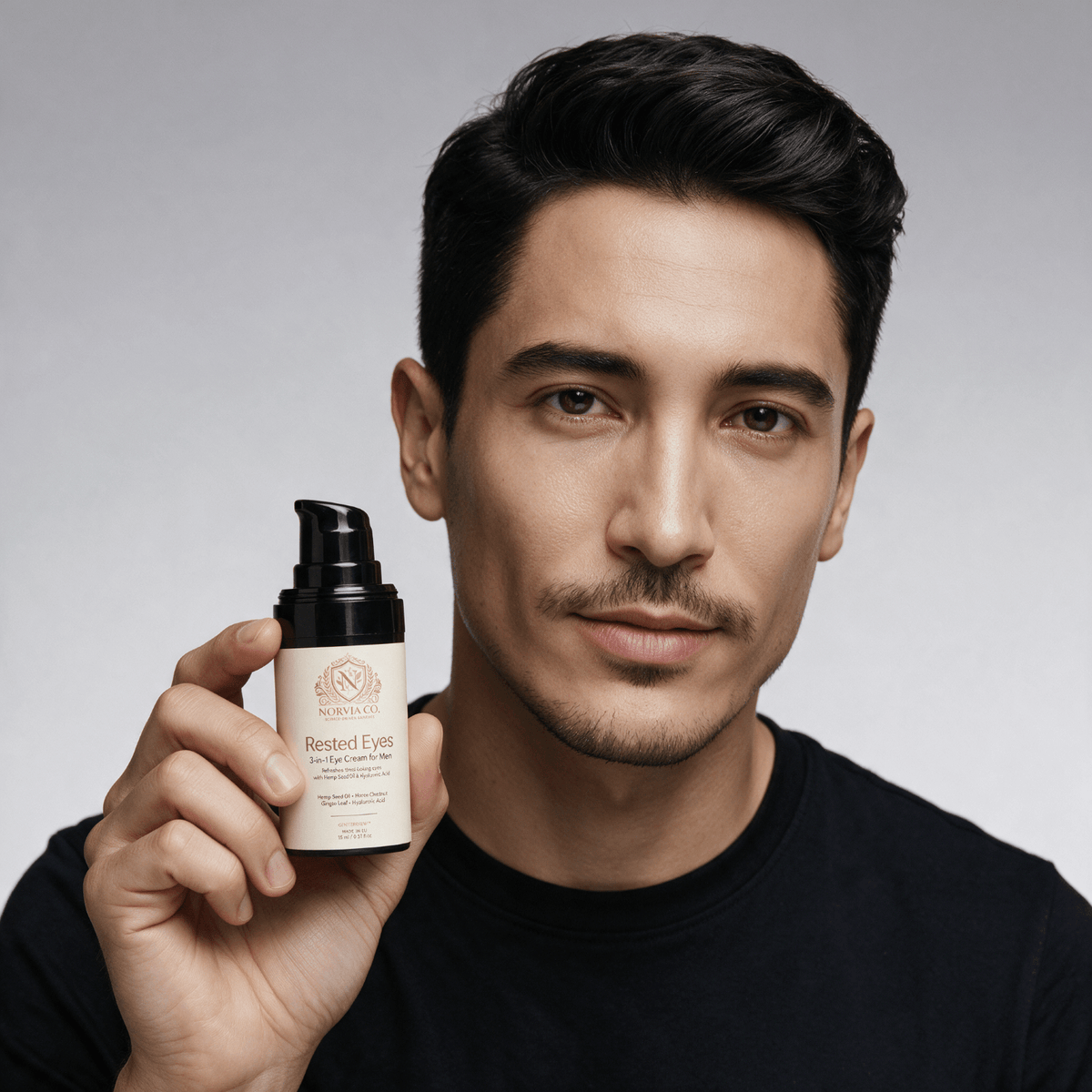 Eye Cream for Men in a cream-colored bottle with a black pump, held beside a man's face