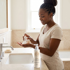 Foam Cleanser for Oily Skin in a white pump bottle, shown dispensing airy mousse into a woman's palm