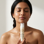 Peptide Face Cream in a white Norvia pump bottle, held beneath a woman's face with clear gel droplets on her skin