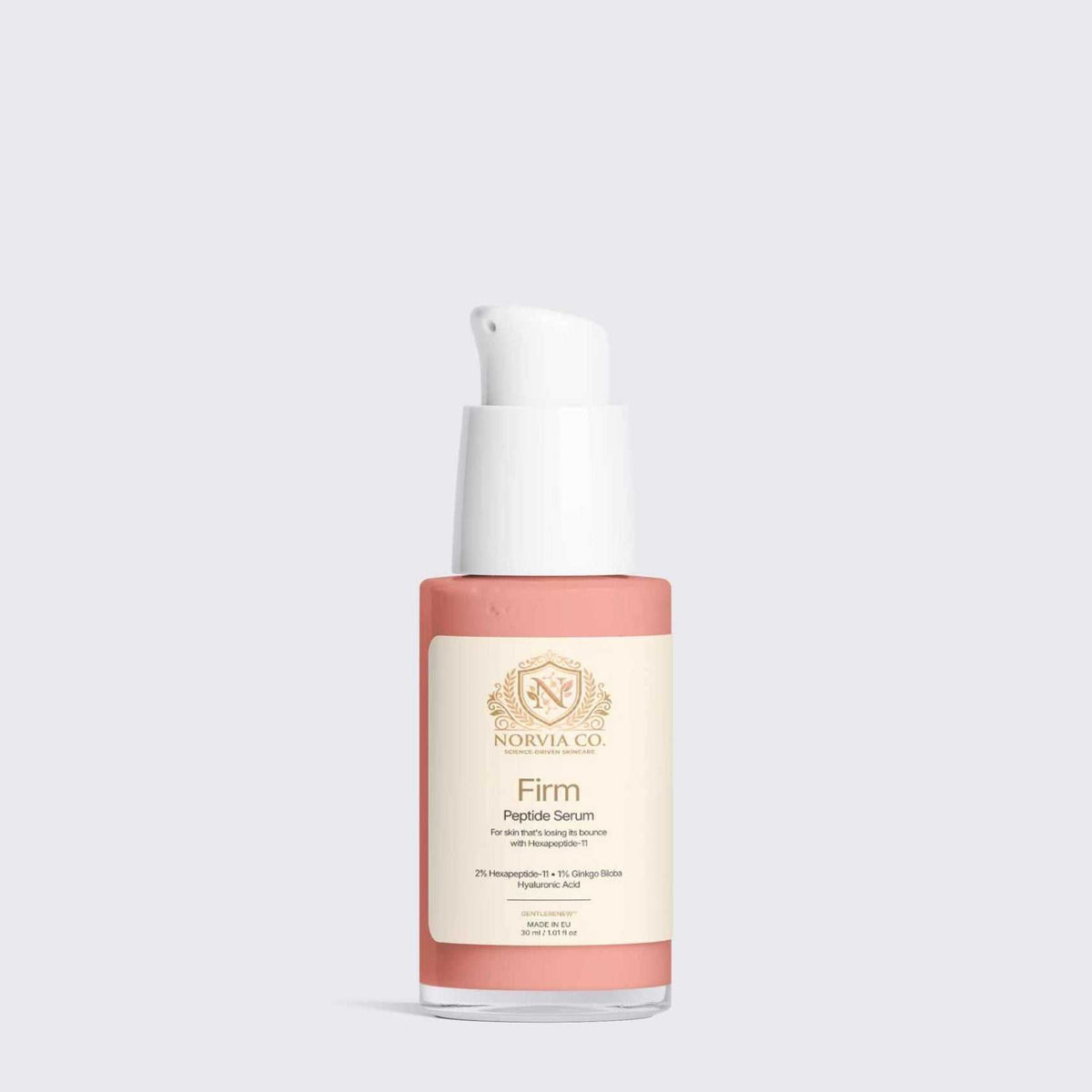 Peptide Serum in a coral pink and cream bottle with a white pump and gold lettering on the label
