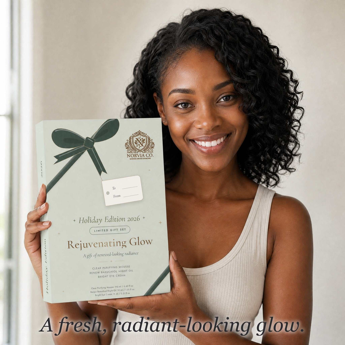 Woman holding the Norvia Co. Rejuvenating Glow holiday gift box, text: A fresh, radiant-looking glow.