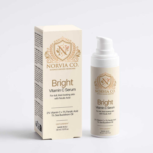 Vitamin C Serum in a white pump bottle with matching cream box, featuring gold ornamental branding and text.