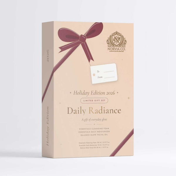A beige rectangular gift box for The Apothecary's Daily Radiance Holiday Edition 2016, decorated with a dark burgundy ribbon graphic and a white gift tag, set against a clean white background.